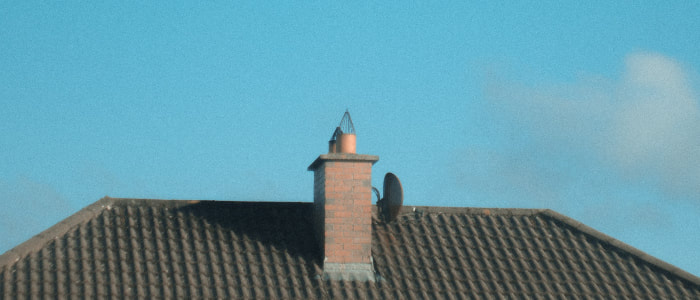 roof with brick chimney and satellite dish